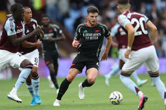 Rice attempts to dribble through a crowd of players