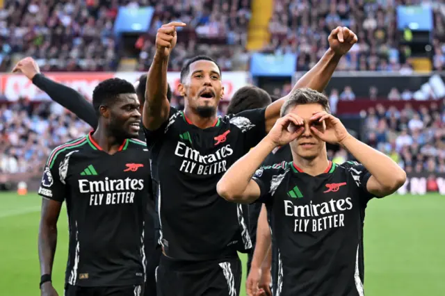 Trossard does his signature celebration as teammates celebrate behind him