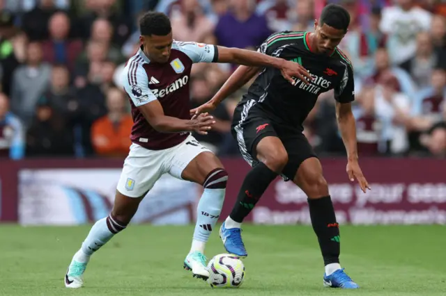 Watkins and Saliba battle for control of the ball