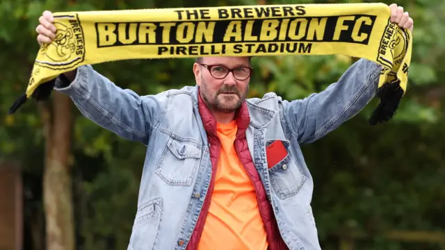 Burton Albion fan raises scarf