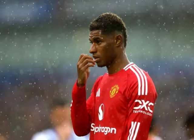 Rashford wipes rain off his face