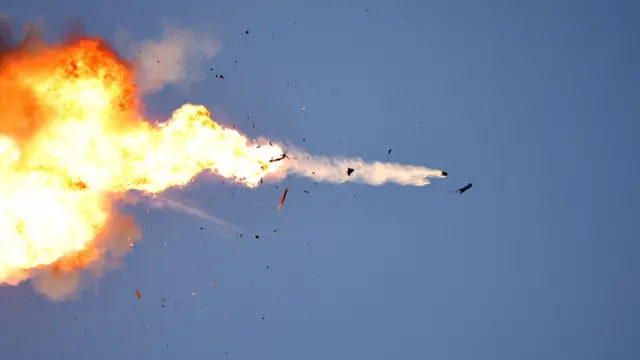 Fire in the sky as an unmanned aerial vehicle (UAV) is intercepted by an Israeli fighter jet.