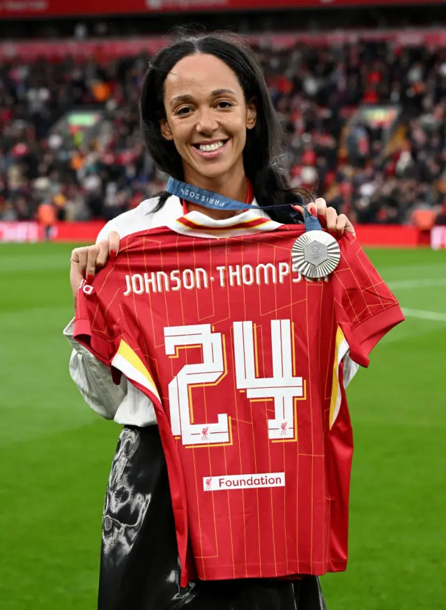 Johnson-Thompson is presented with a Liverpool shirt on the pitch at half time