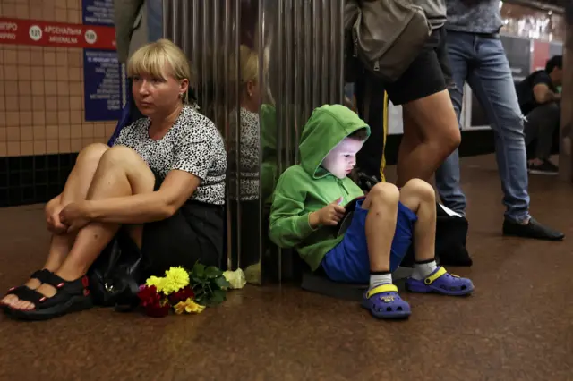 A child and a women sheltering in a metro station