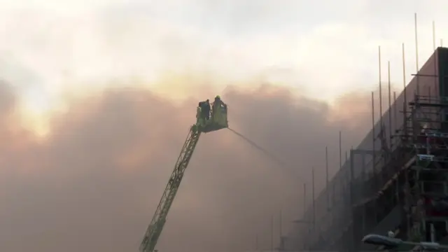 Firefighters tackling Dagenham blaze using crane.