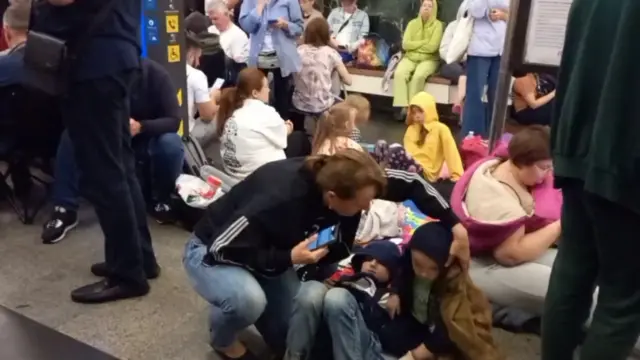 Two children and a women sheltering in a metro station