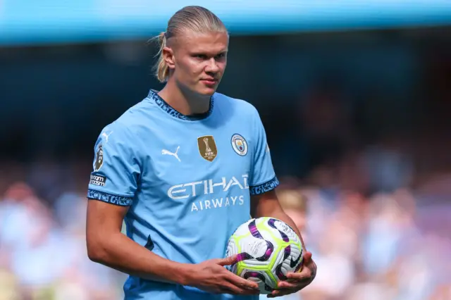 Erling Haaland holding the Premier League ball