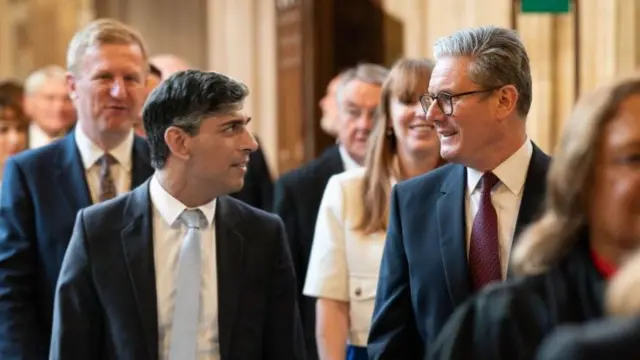 Prime Minister Keir Starmer (R) and Leader of the Opposition Rishi Sunak walking through the Member's Lobby of the Houses of Parliament in London to the House of Lords to hear the King's Speech during the State Opening of Parliament, on July 17