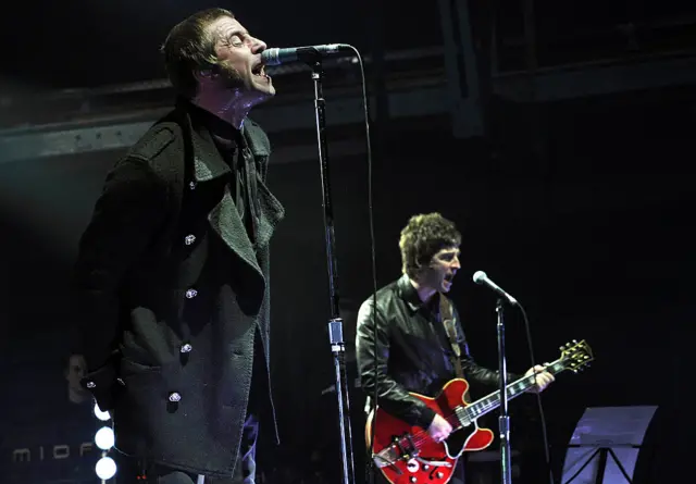 Liam and Noel Gallagher (R) of the band Oasis perform on stage in the southern German city of Munich