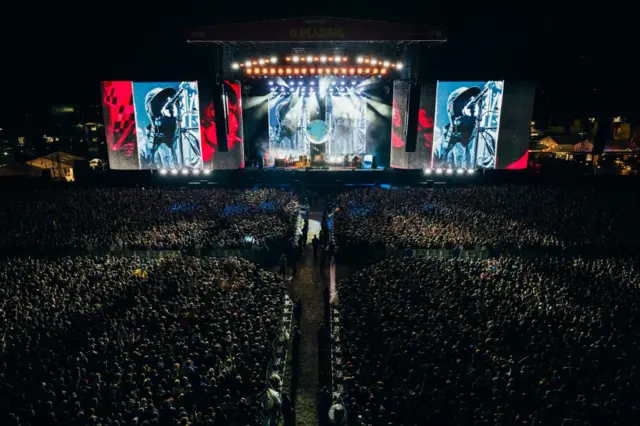 A shot from distance of Liam Gallagher playing to a huge crowd at the Reading festival