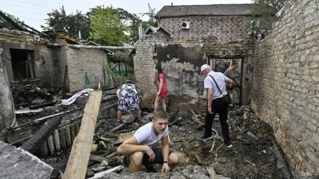 People search through the rubble of a building hit by a Russian strike in Zaporizhzhia