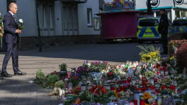 German Chancellor Olaf Scholz lays down a flower near the crime scene in Solingen, Germany