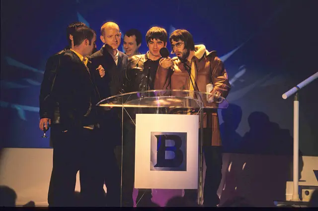 Alan McGee on stage with Oasis at the Brit Awards in 1996