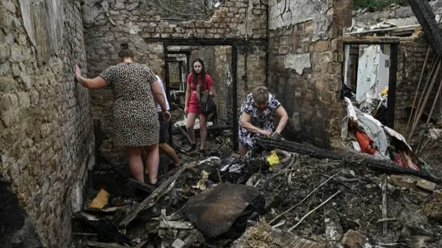 Local residents collect things in their destroyed building hit by a Russian missile strike, amid Russia's attack on Ukraine, in Zaporizhzhia, Ukraine , August 27, 2024