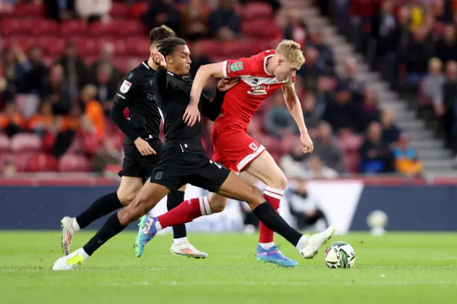 Josh Coburn of Middlesbrough battles for possession with Ashley Phillips of Stoke City