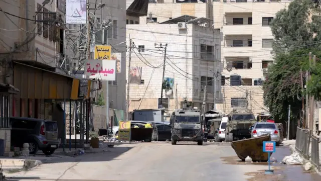 Israeli army vehicles are parked outside a hospital during a military operation in the West Bank city of Jenin, 28 August 2024