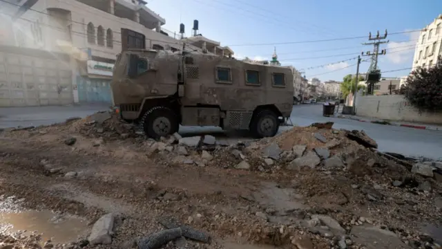 n Israeli military vehicle drives down a road during a raid in northern city of Tulkarm