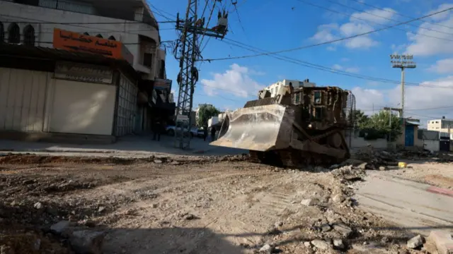 An Israeli military bulldozer drives down a road during a raid in northern city of Tulkarm in the occupied West Bank on August 28, 2024.