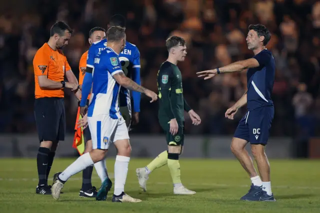 Colchester United manager Danny Cowley takes his players away from protesting to the referee