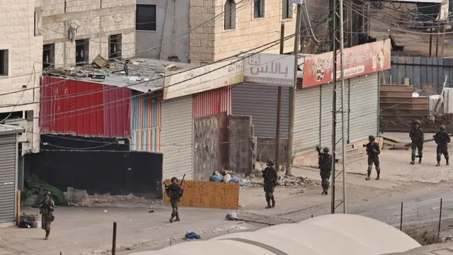 Israeli soldiers walk down a street during a raid in the al-Faraa camp for Palestinian refugees near Tubas city in the occupied West Bank on August 28, 2024.