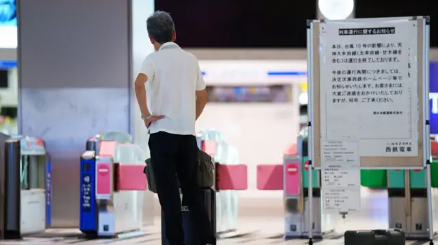 A man reads the cancellation notices in Fukuoka's Tenjin station