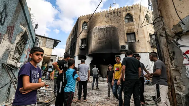 Children standing outside a mosque, which has been burned