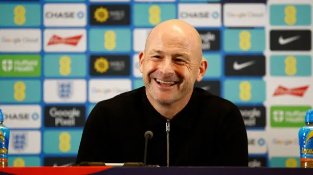 Lee Carsley smiles at an England news conference