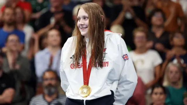 Poppy Maskill stands with her gold medal