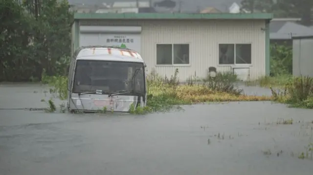 A bus submerged in floodwaters in Yufu city, Oita prefecture