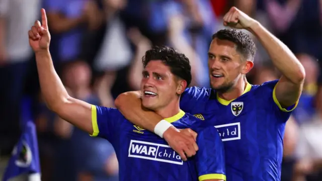 Matty Stevens celebrates with James Ball during Wimbledon's Carabao Cup win over Ipswich Town