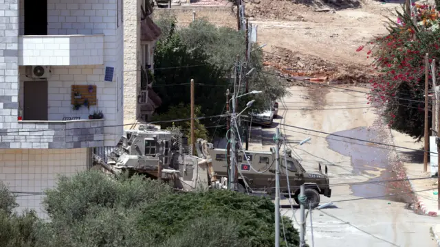 Israeli army vehicles are seen in a refugee camp in Jenin