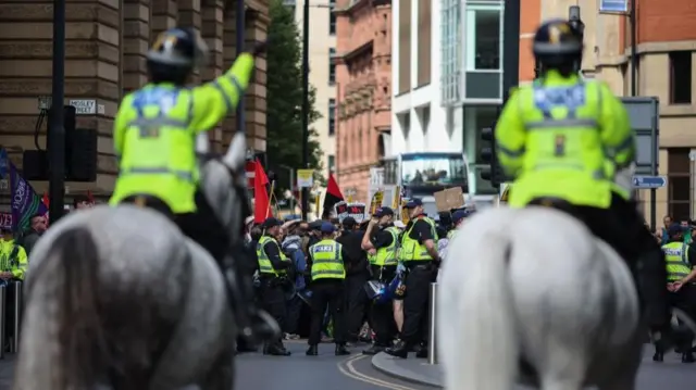 Police on horseback and protesters