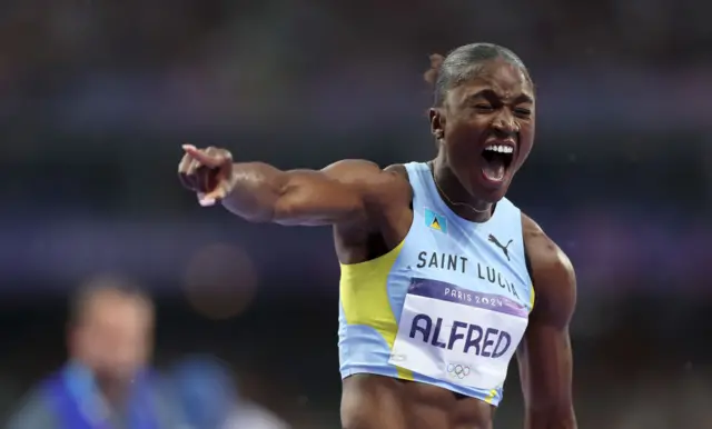 Julien Alfred celebrates her 100m win