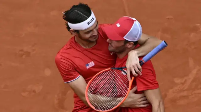 US' Taylor Fritz (L) and US' Tommy Paul (R) embrace as they celebrate beating Czech Republic's Tomas Machac and Czech Republic's Adam Pavlasek in their men's doubles bronze medal tennis match