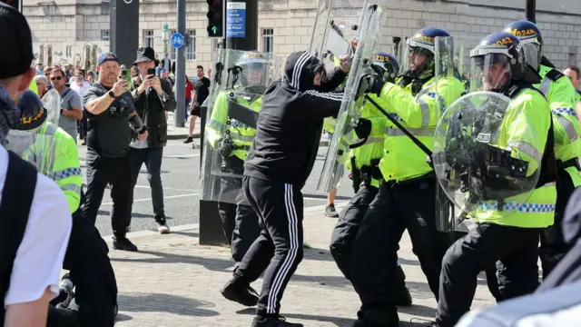 Police officers and demonstrators clash