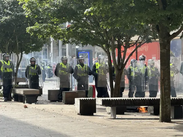 Riot police force a block in the middle of the road