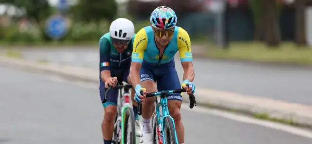 Kazakhstan's Alexey Lutsenko (R) and Ireland's Ben Healy (L) cycle in a chase group during the men's cycling road race during the Paris 2024 Olympic Games