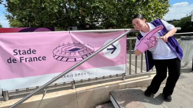 Paris 2024 volunteer points to Stade de France