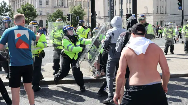 Police officers and demonstrators clash during a protest in Liverpool,