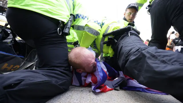 Police officers arresting a man on the ground