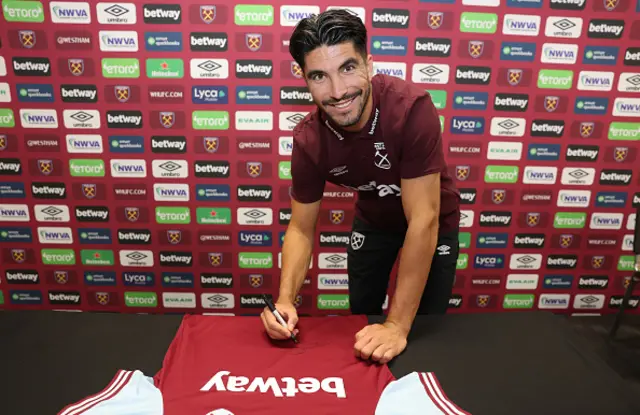 Carlos Soler signs a West Ham shirt