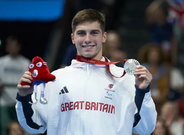 William Ellard holds aloft his Paralympic silver medal