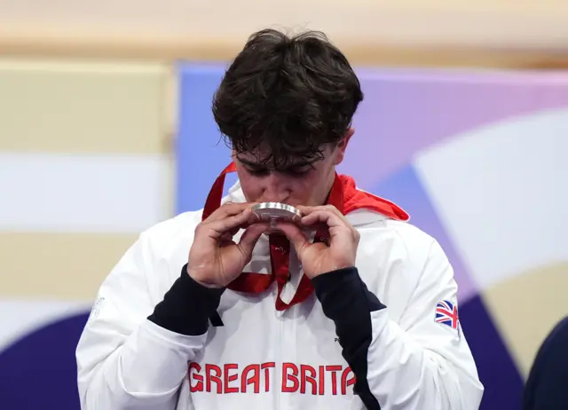 Archie Atkinson kisses his silver medal