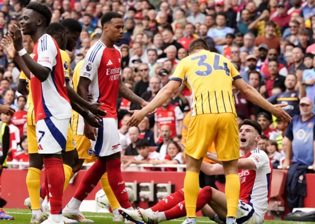 Declan Rice (right) sits on the floor as he argues with Brighton & Hove Albion's Joel Veltman (second right) before receiving a second yellow car