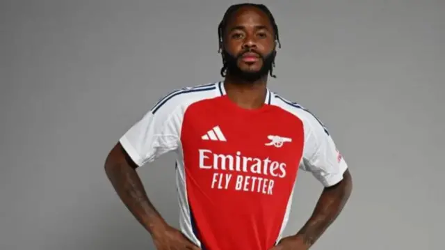 Raheem Sterling poses in an Arsenal shirt