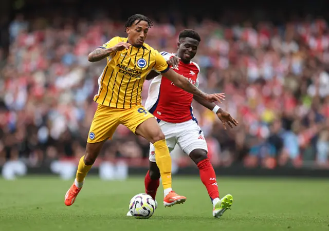 Joao Pedro of Brighton & Hove Albion is challenged by Bukayo Saka