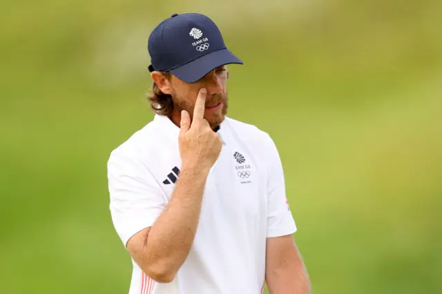 Fleetwood wipes his face after a frustrating putt