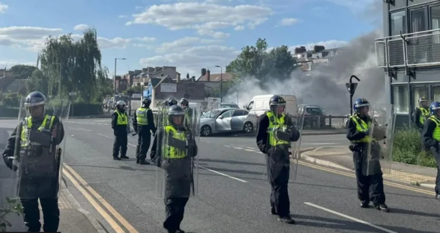 Protesters and damaged cars