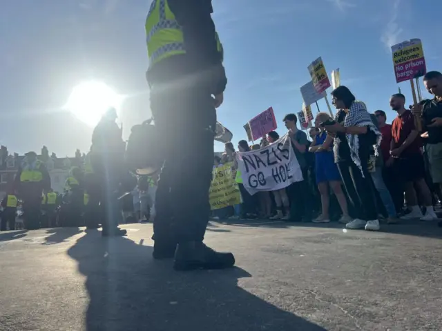 Police officers line up in front of anti-racism demonstrators in Weymouth