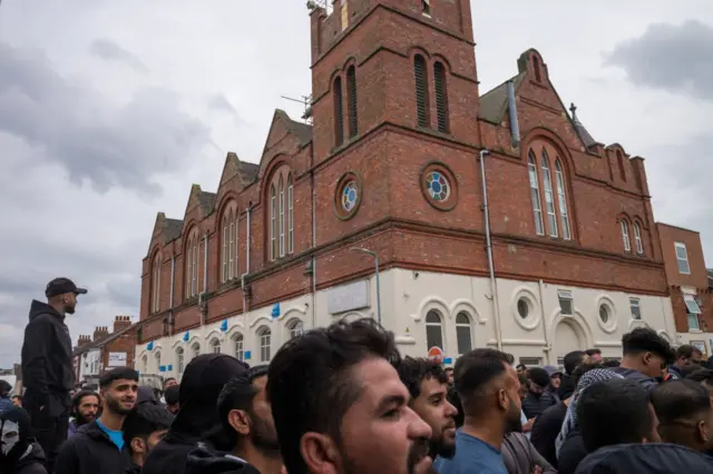 Crowd gathers to guard a mosque